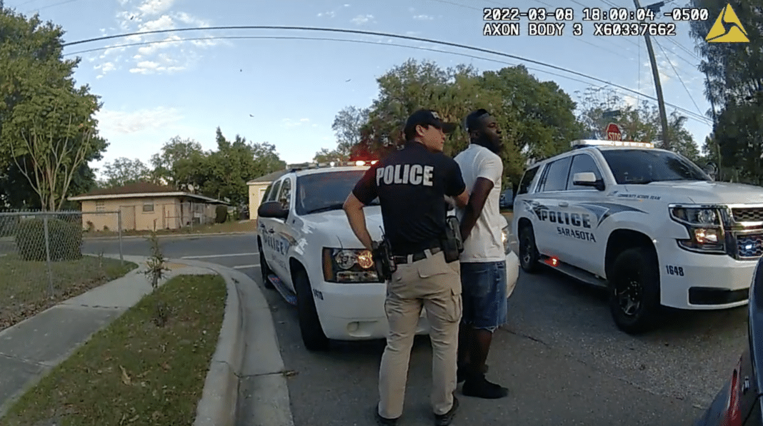 Sarasota Police Bodycam: Convicted Felon Arrested After Firearm Found in Traffic Stop Police officer arrests man near patrol cars.
